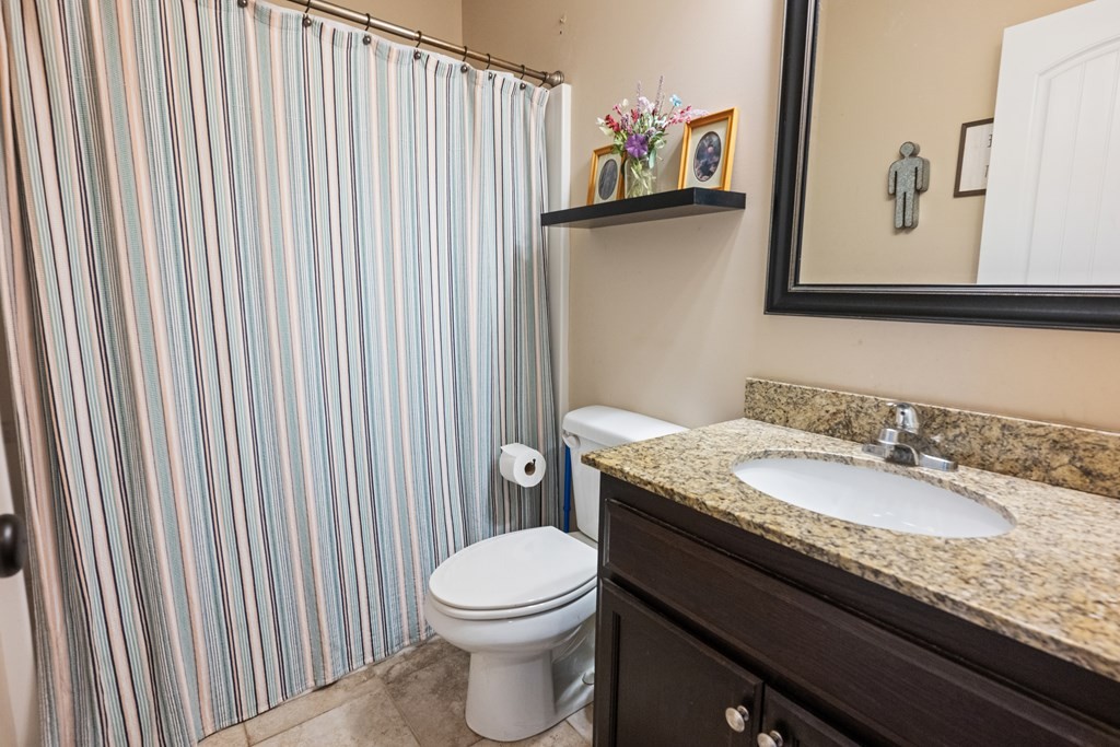 5006 Jimmie Neal Road Baxter, TN 38544 - Photo 16 of 22 a bathroom with a granite countertop toilet sink and mirror
