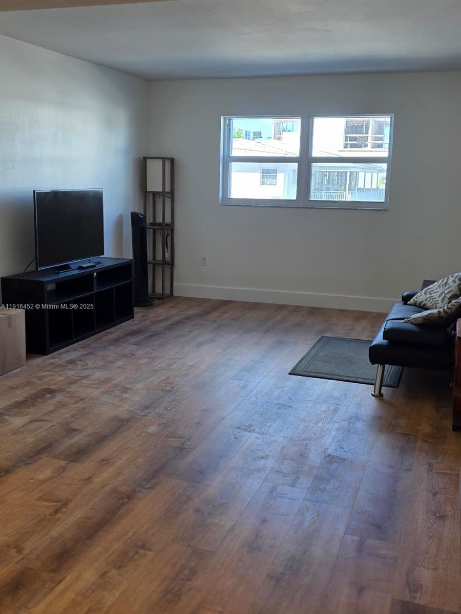 7440 Harding Avenue, Unit 204 Miami Beach, FL 33141 - Photo 15 of 37 a living room with furniture and a flat screen tv