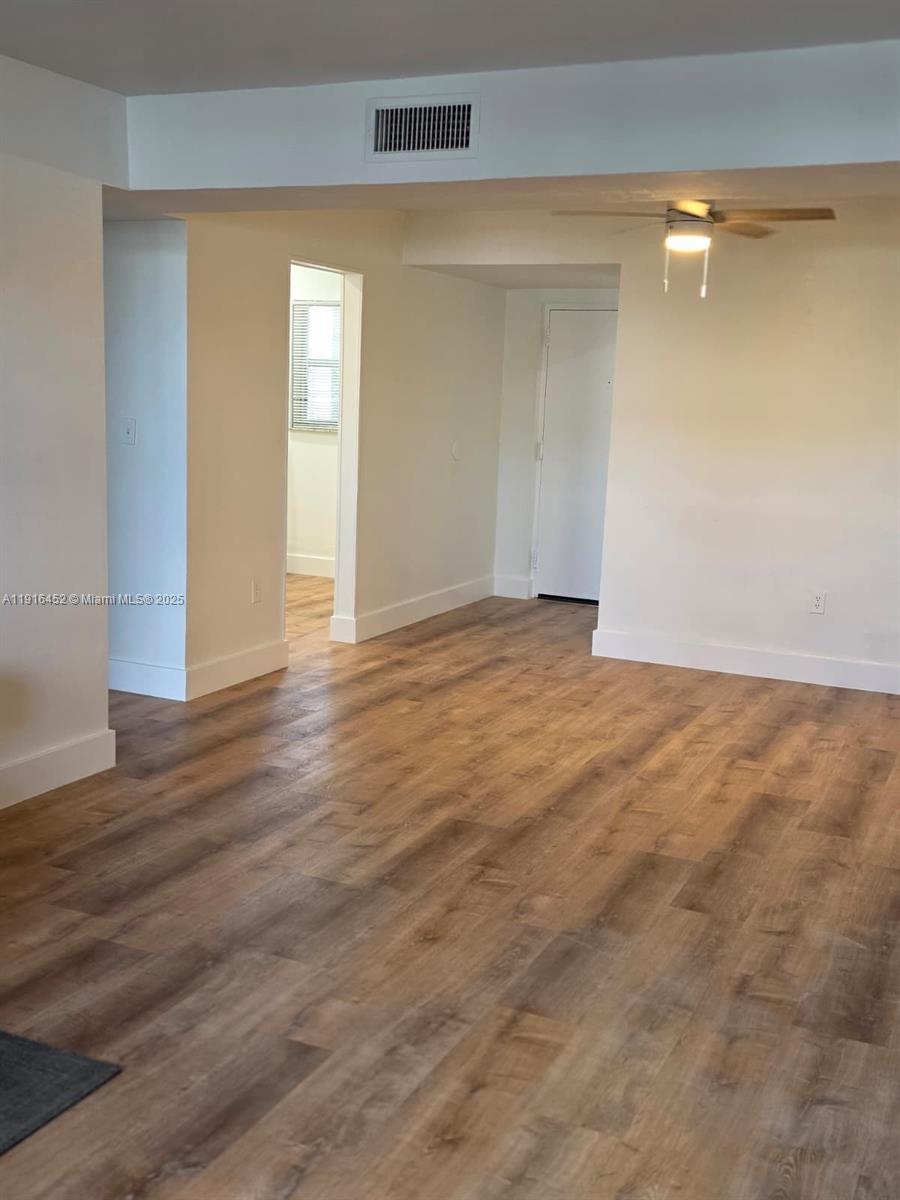 7440 Harding Avenue, Unit 204 Miami Beach, FL 33141 - Photo 18 of 37 a view of an empty room with wooden floor and a window
