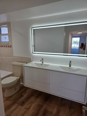 a bathroom with a toilet a sink and mirror