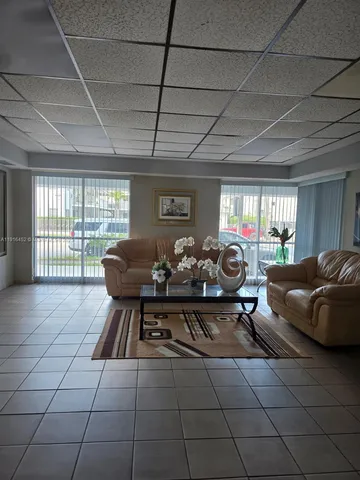 a living room with furniture a flat screen tv and a large window