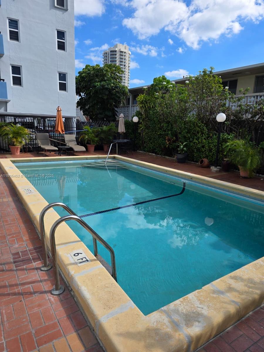 7440 Harding Avenue, Unit 204 Miami Beach, FL 33141 - Photo 10 of 37 a view of a swimming pool with a lounge chairs