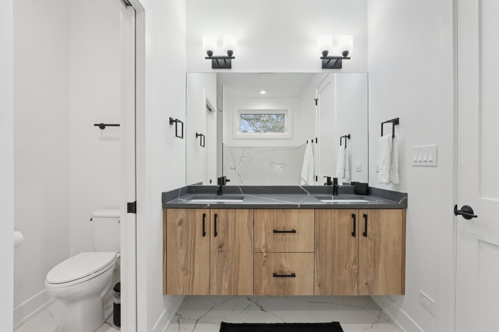 4119 North Ashland Avenue, Unit 3N Chicago, IL 60613 - Photo 24 of 33 a bathroom with a granite countertop sink a toilet and a mirror