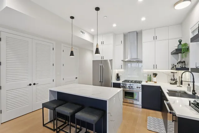 a kitchen with stainless steel appliances a sink stove and refrigerator