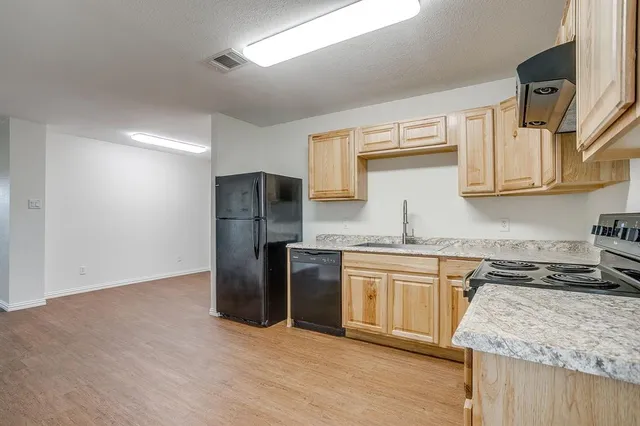 a kitchen with stainless steel appliances granite countertop a refrigerator and a stove top oven