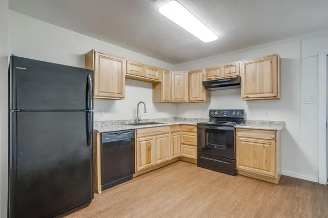 a kitchen with stainless steel appliances granite countertop a refrigerator stove and sink