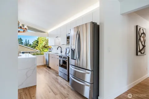a kitchen with white cabinets and stainless steel appliances