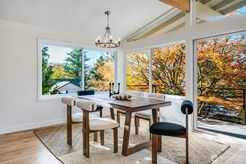 a view of a dining room with furniture large windows and wooden floor