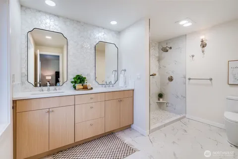 a spacious bathroom with a shower a sink and mirror