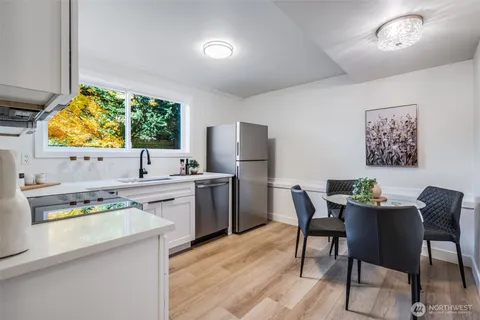 a kitchen with a dining table chairs cabinets and stainless steel appliances