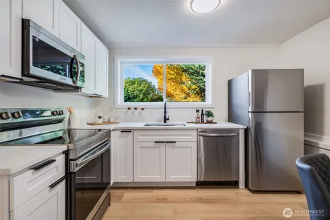 a kitchen with stainless steel appliances a sink cabinets and a refrigerator