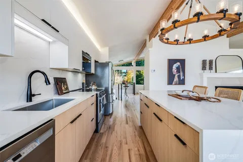 a kitchen with stainless steel appliances a sink a stove and a wooden floors