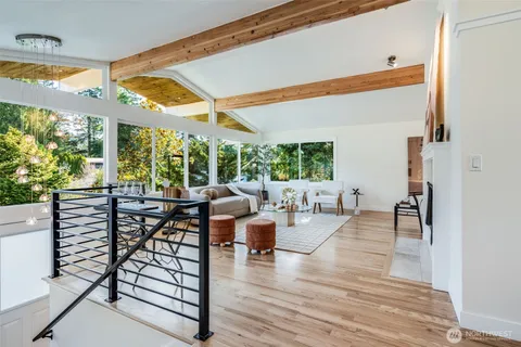a very nice looking living room with a large window and wooden floor
