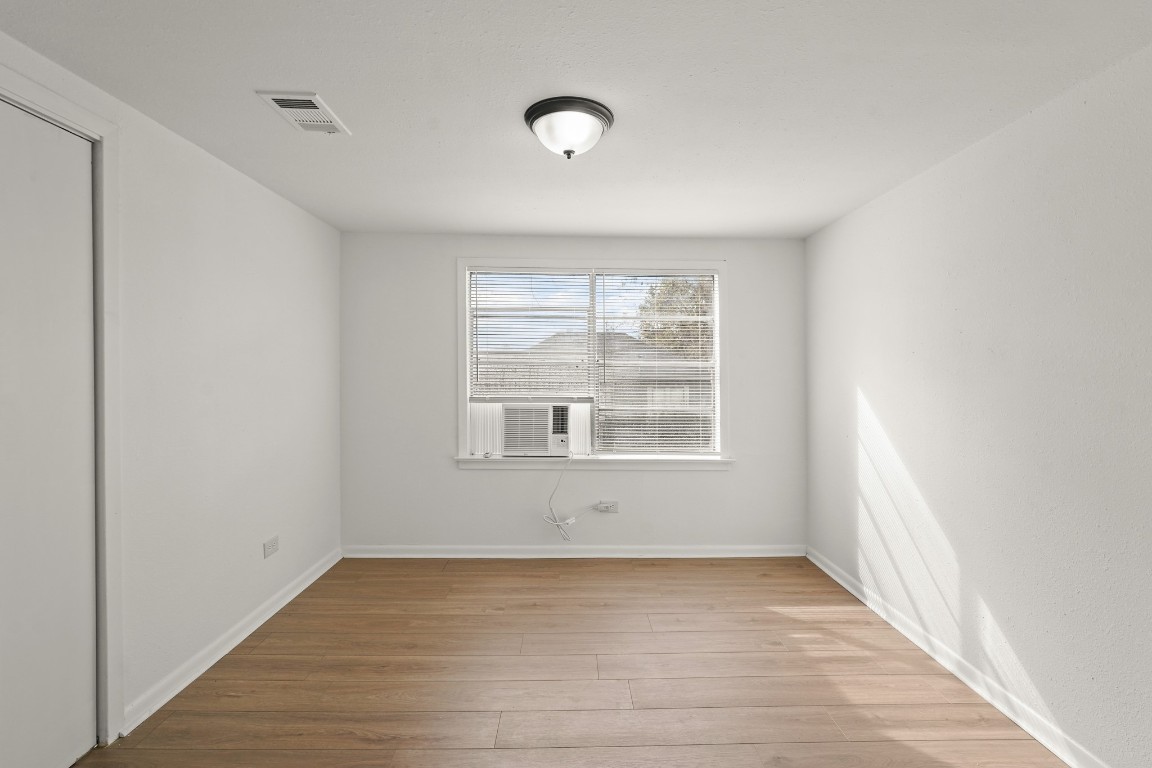 105 West Linney Street Dayton, TX 77535 - Photo 12 of 48 a view of an empty room with wooden floor and a window