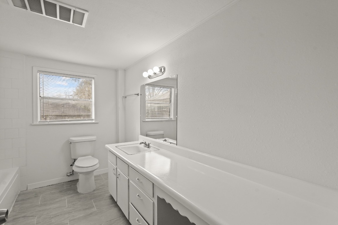 105 West Linney Street Dayton, TX 77535 - Photo 13 of 48 a spacious bathroom with a toilet sink and mirror