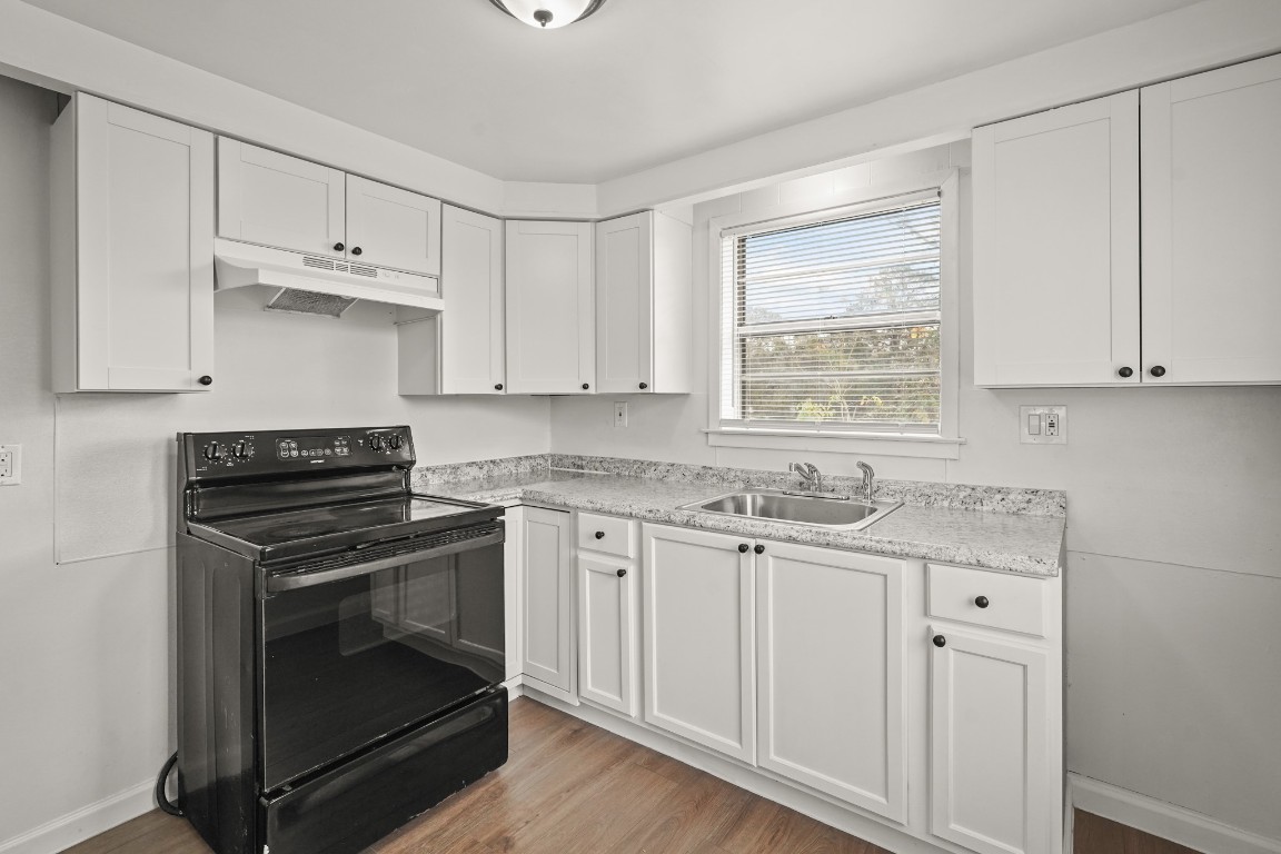 105 West Linney Street Dayton, TX 77535 - Photo 19 of 48 a kitchen with granite countertop white cabinets and white appliances