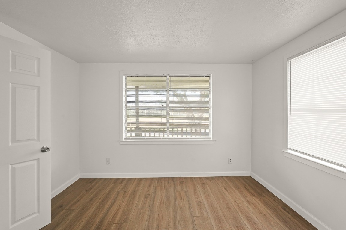 105 West Linney Street Dayton, TX 77535 - Photo 22 of 48 an empty room with wooden floor and windows