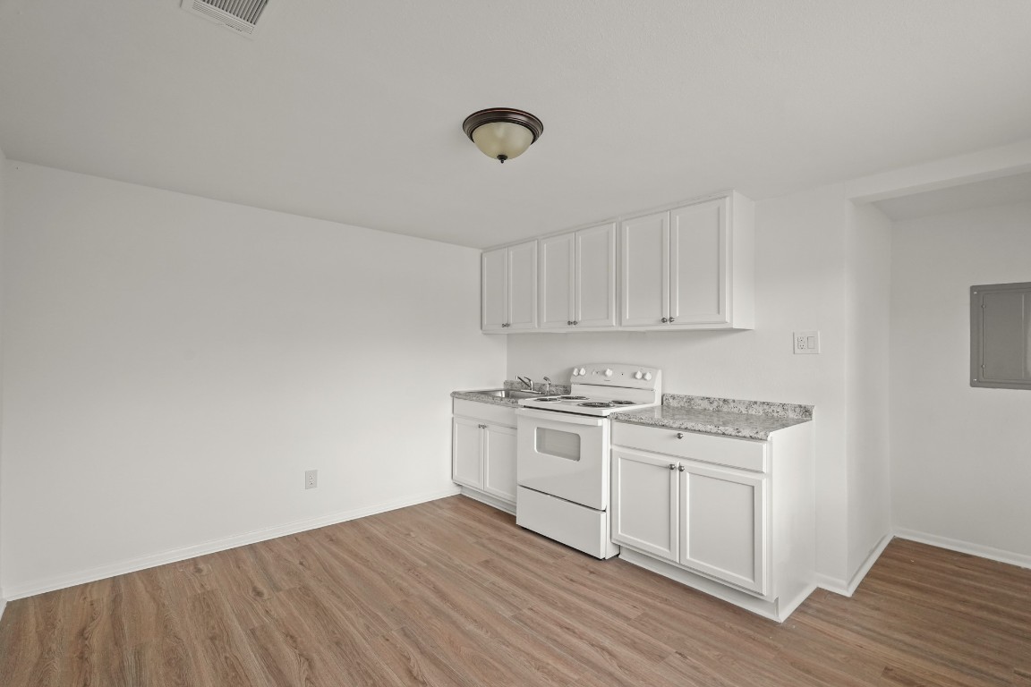 105 West Linney Street Dayton, TX 77535 - Photo 32 of 48 a kitchen with granite countertop a stove cabinets and wooden floor