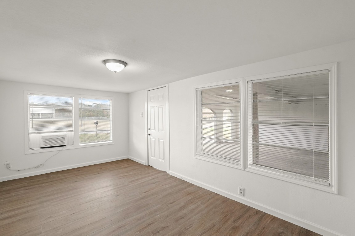 105 West Linney Street Dayton, TX 77535 - Photo 36 of 48 an empty room with wooden floor and windows