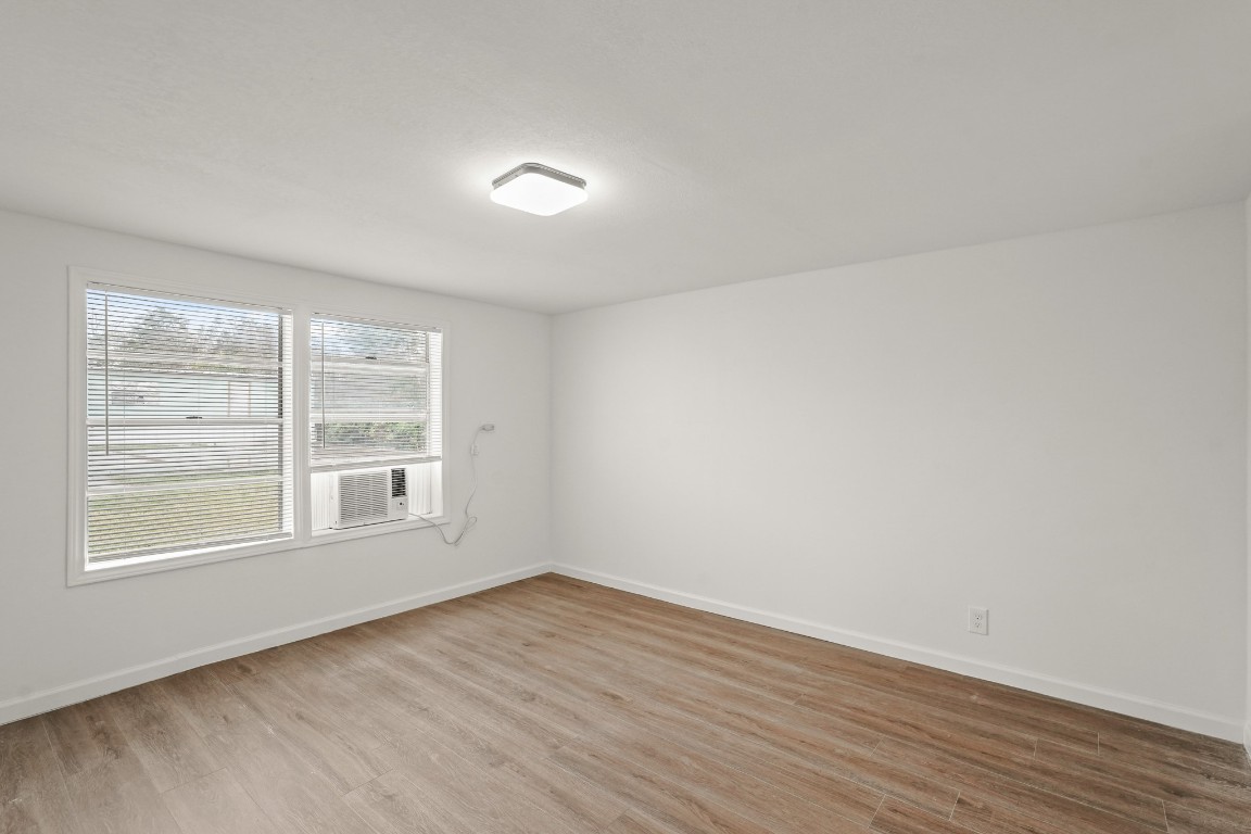 105 West Linney Street Dayton, TX 77535 - Photo 40 of 48 an empty room with wooden floor and windows