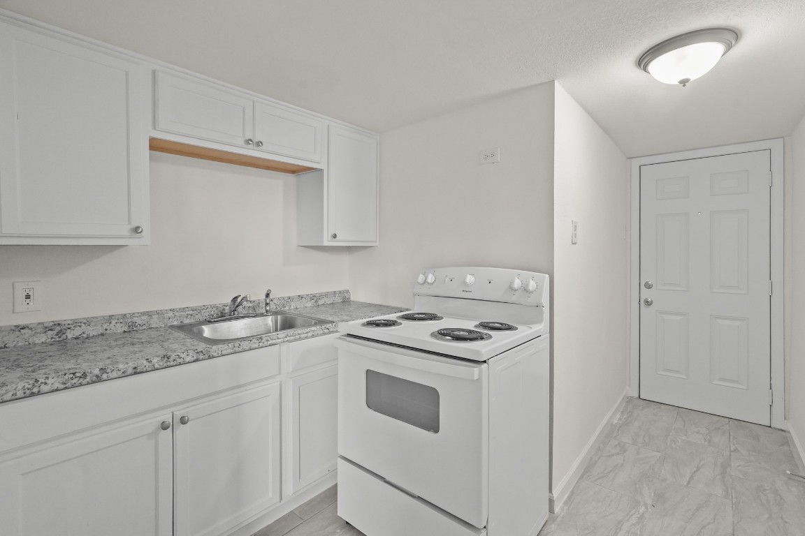 105 West Linney Street Dayton, TX 77535 - Photo 46 of 48 a kitchen with a stove sink and cabinets