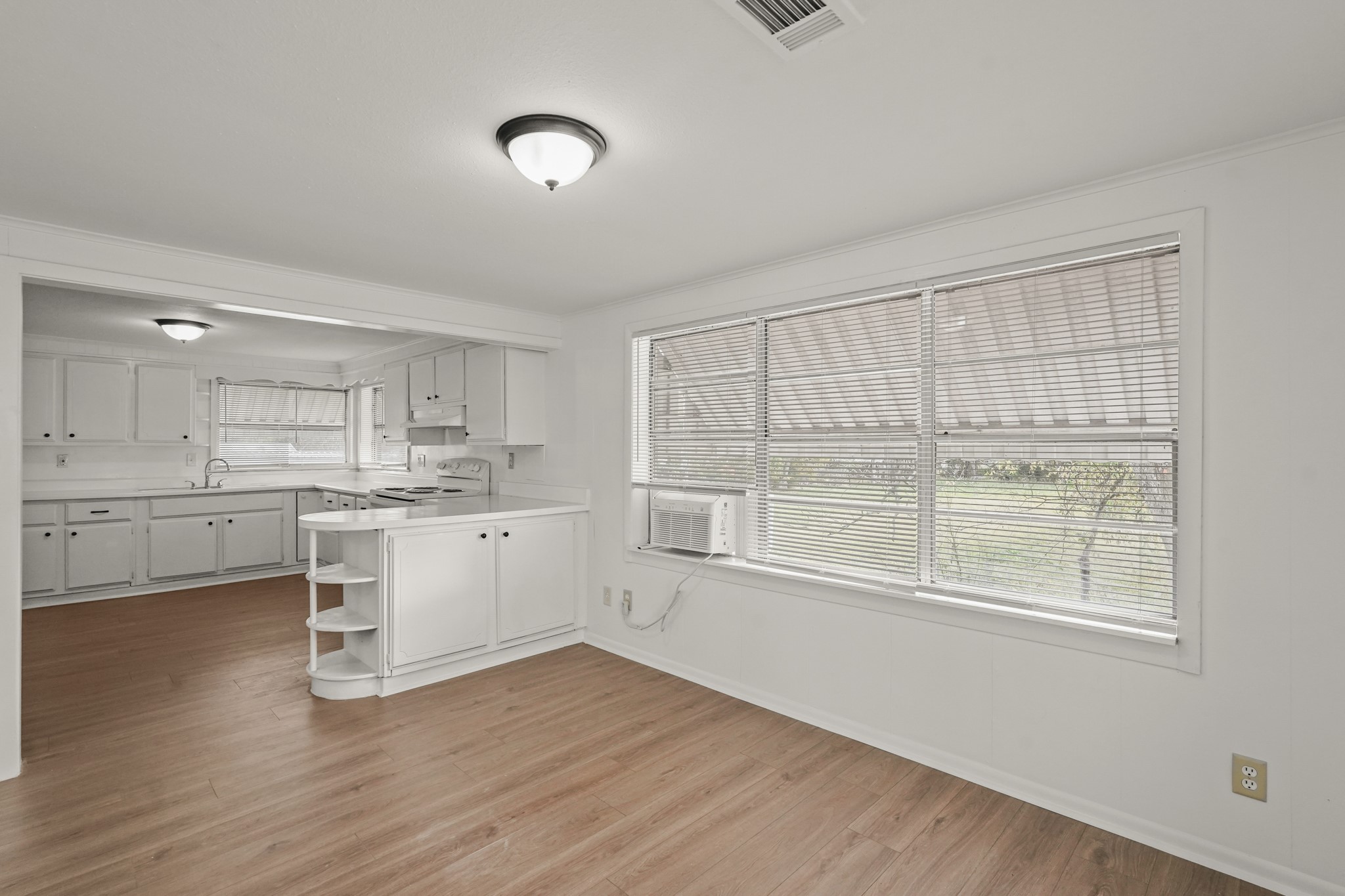 105 West Linney Street Dayton, TX 77535 - Photo 9 of 48 a kitchen with white cabinets and wooden floor