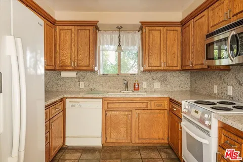 a kitchen with stainless steel appliances granite countertop a sink stove and cabinets