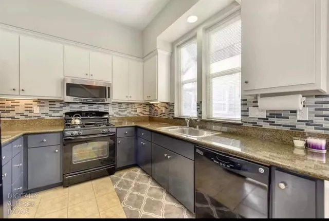 a kitchen with stainless steel appliances granite countertop a stove a sink and a microwave