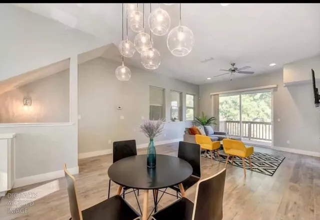 a view of a dining room with furniture a chandelier and wooden floor