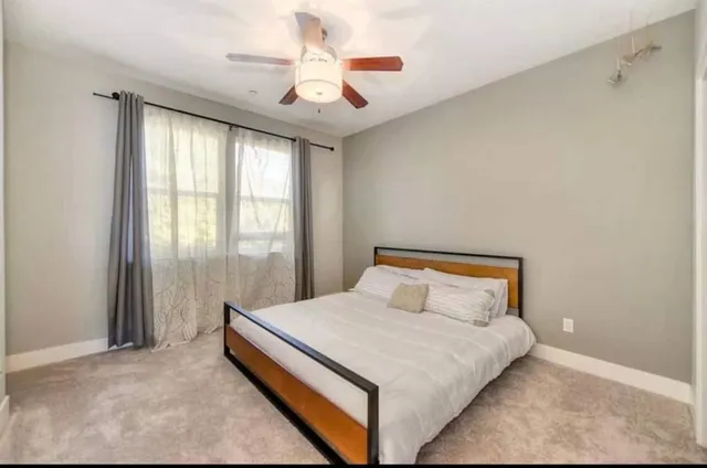 a bedroom with a large bed and a chandelier