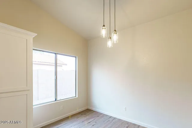 a living room with stainless steel appliances kitchen island a chandelier and wooden floor