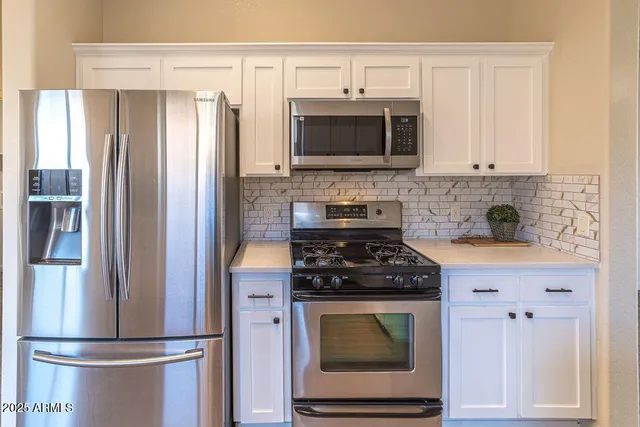 a kitchen with stainless steel appliances granite countertop a refrigerator stove and microwave