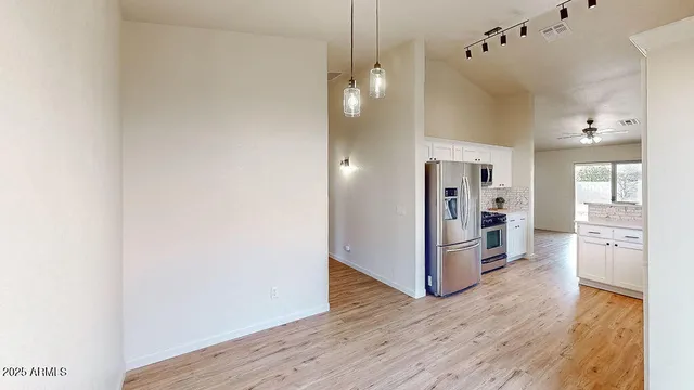 an empty room with a window and a fan