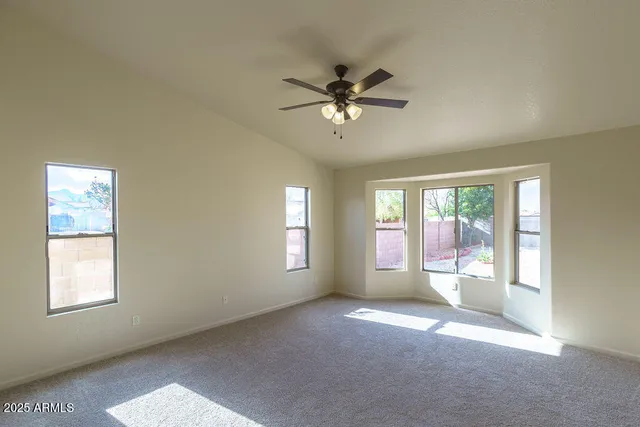 an empty room with a chandelier fan and closet area