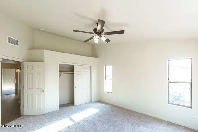 an empty room with a window and a fan