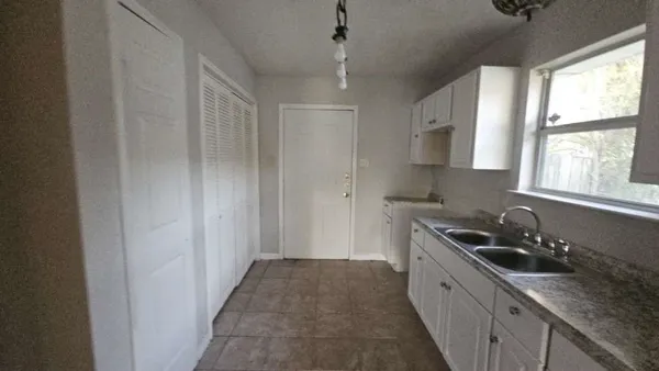 a kitchen with sink a window and appliances