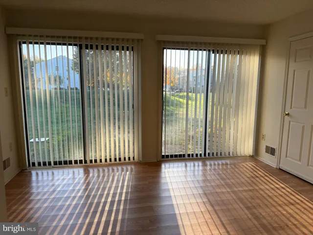 a view of a room with wooden floor and a floor to ceiling window
