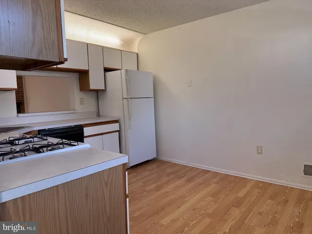 a kitchen with a refrigerator and a stove top oven