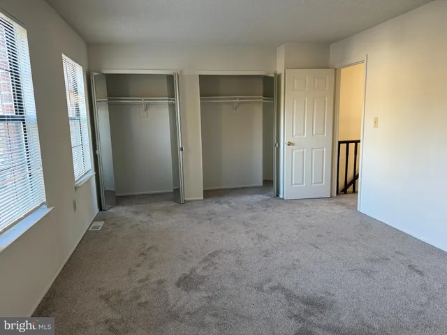 an empty room with closet and windows