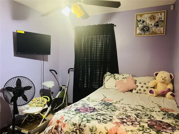 a bedroom with a bed and a flat screen tv