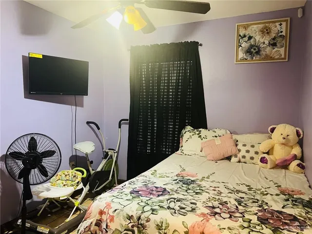 a bedroom with a bed and a flat screen tv