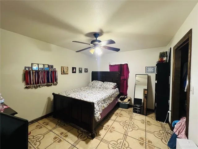 a living room with a bed dresser and a chandelier