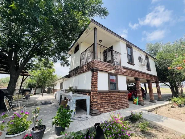 a view of a house with a yard and potted plants
