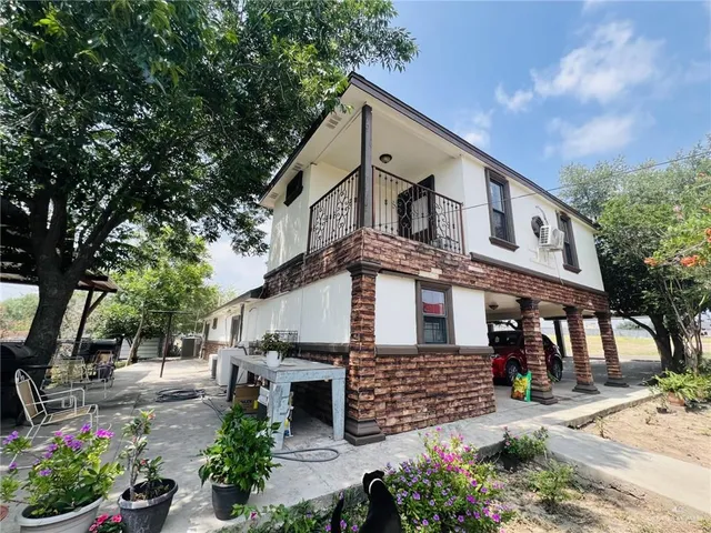 a view of a house with a yard and potted plants