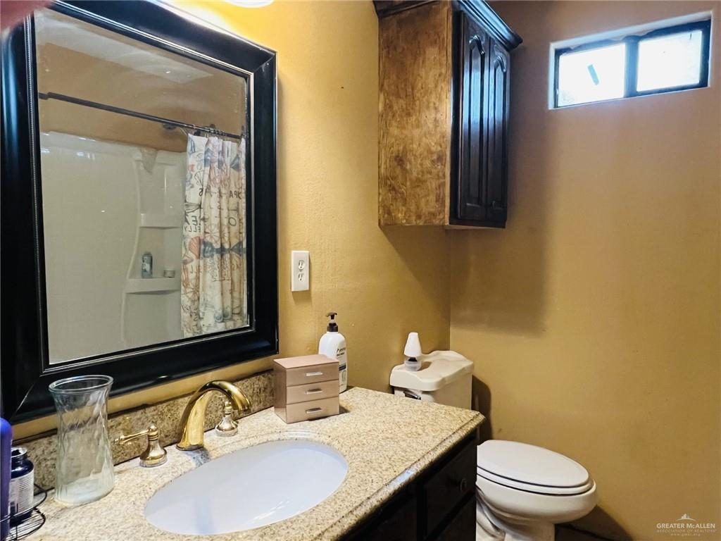 5 Montalvo Hill Road Rio Grande City, TX 78582 - Photo 35 of 42 a bathroom with a granite countertop toilet a sink and mirror