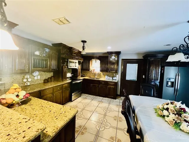 a kitchen with stainless steel appliances kitchen island granite countertop a sink and cabinets