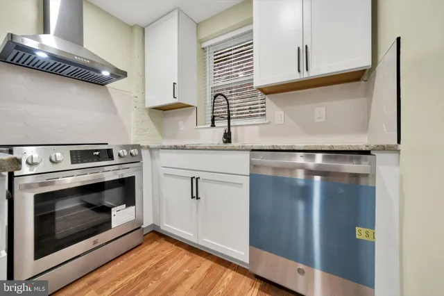 a kitchen with stainless steel appliances granite countertop a stove and a microwave