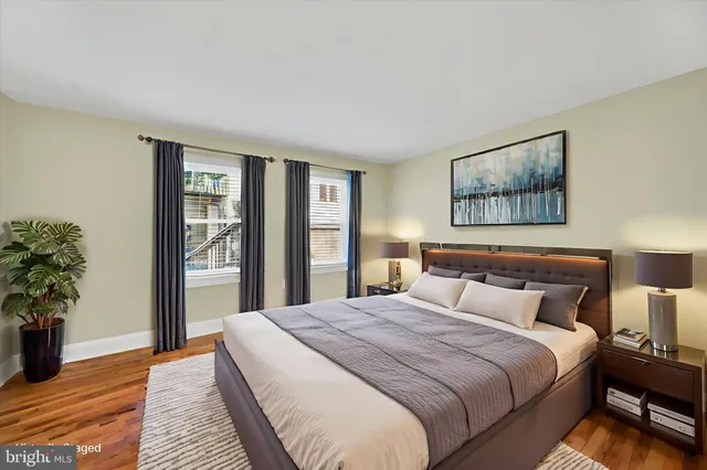 a bedroom with a large bed and a potted plant