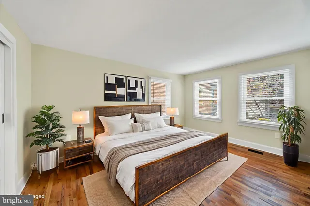 a spacious bedroom with a bed and a potted plant