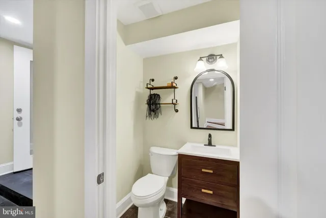 a bathroom with a toilet a sink and mirror